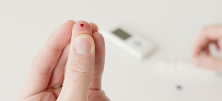 Person checking blood glucose with a finger-prick test.