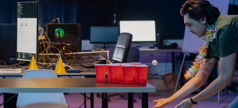 A guy playing a beer pong