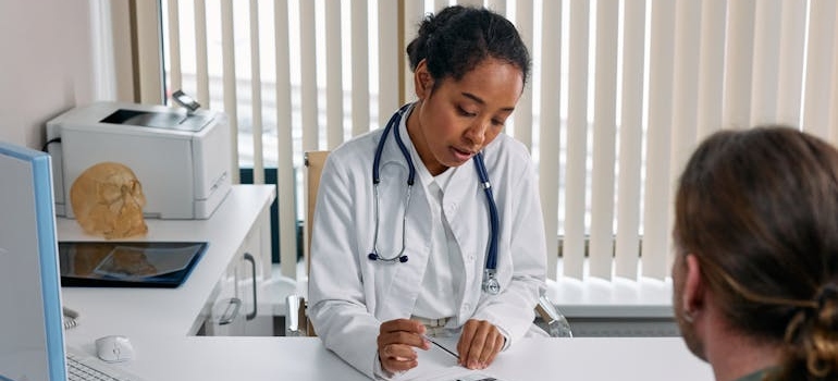 Doctor writing a prescription for a patient.