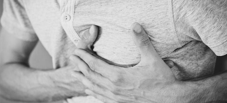 Black and white picture of a man holding his chest.