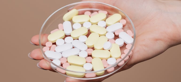 Colorful tables on a glass container as a symbol of Amphetamine vs. Methamphetamine debate.