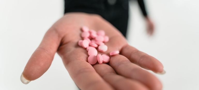 A hand with pink pills