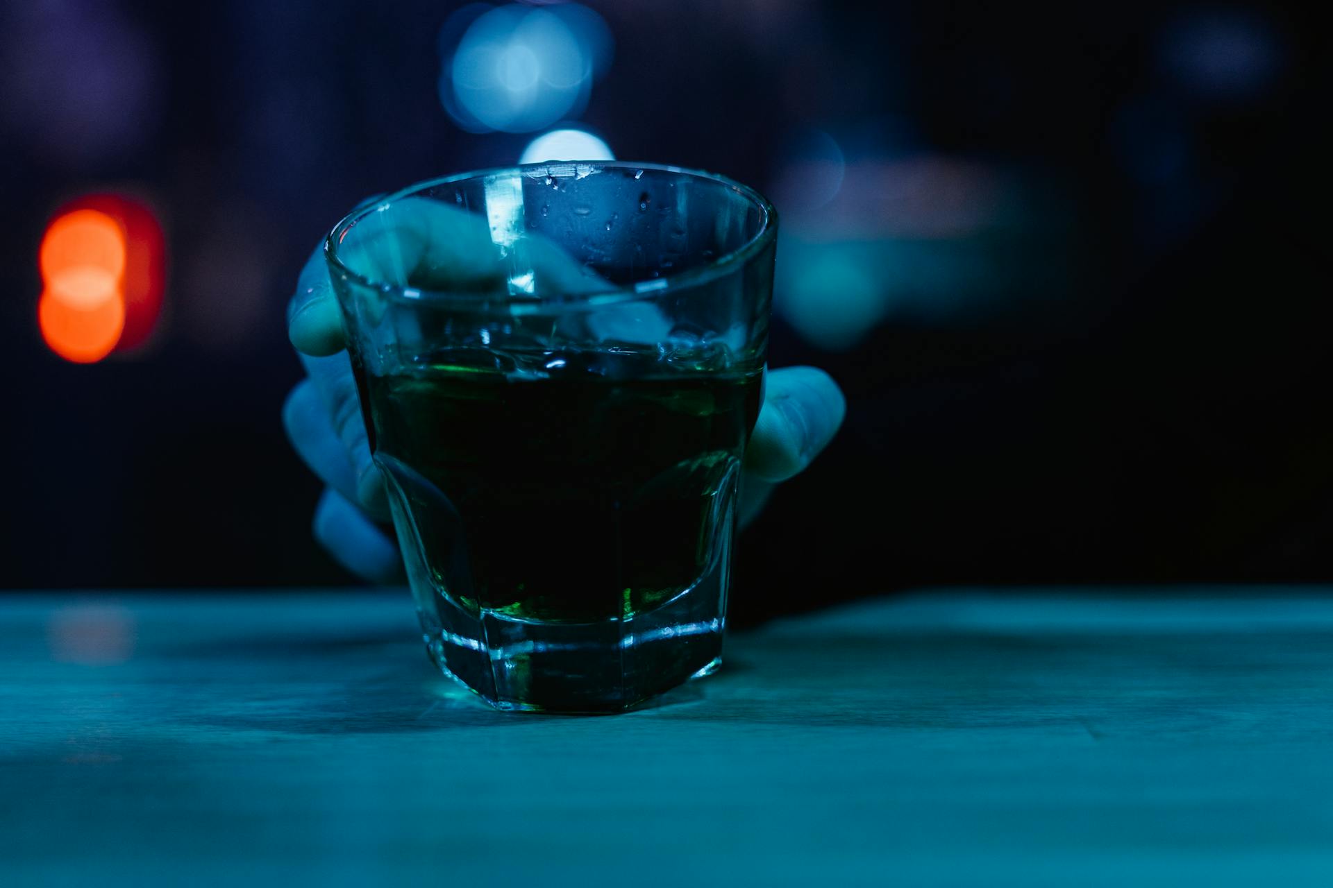 a man holding a glass of alcohol