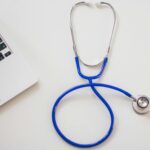 stethoscope and laptop on a white desk
