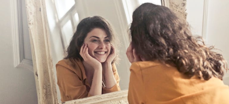 Woman looking at herself in the mirror and smiling.