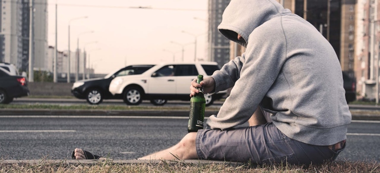 a man holding a bottle of beer struggling with Alcohol and Diabetes