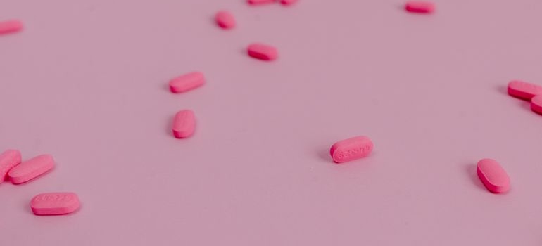 Pink pills on a pink background.