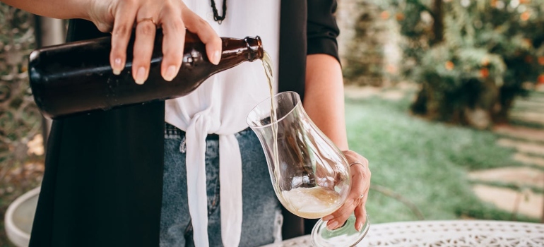 a woman pouring beer in a glass 