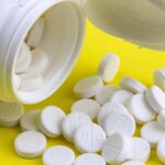 white pills on a yellow surface representing
