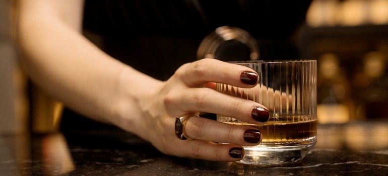 A woman's hand holding a drink.