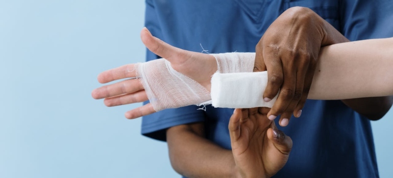 A person getting his hand bandaged