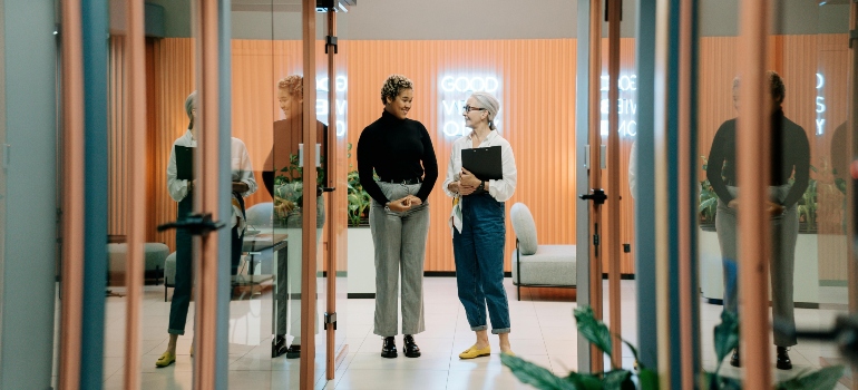 Two women talking in an office hall