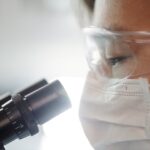 man looking through a microscope searching for drugs are likely to interfere with urine drug screens