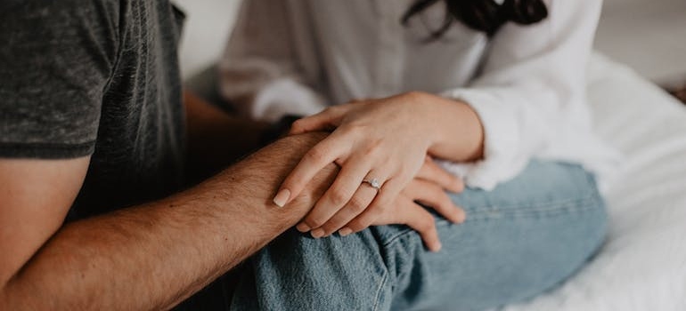 Woman holding a man's hand.