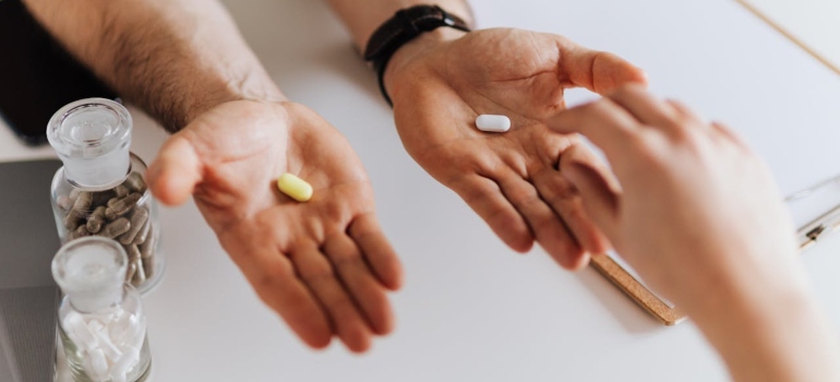 Doctor giving pills to patient