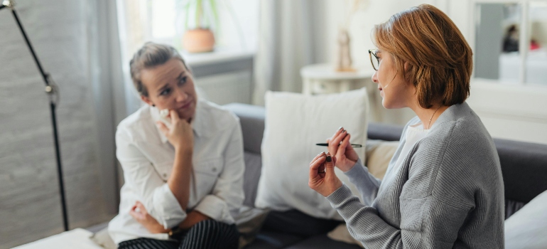 Therapist and her female patient talking about how home rehab may not be safe