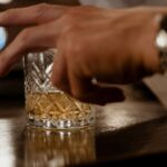 A hand with a glass as a symbol of how to keep your career while in alcohol rehab