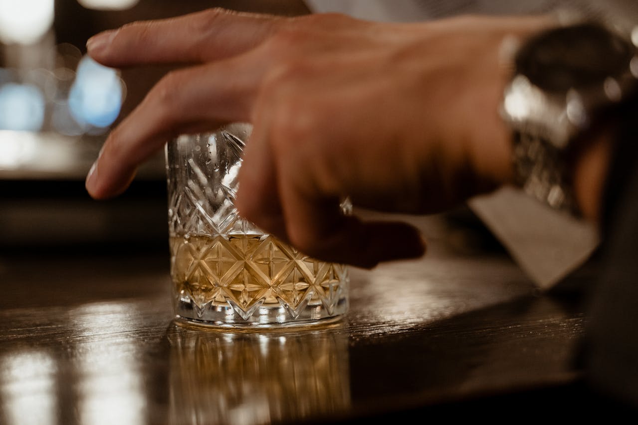 A hand with a glass as a symbol of how to keep your career while in alcohol rehab