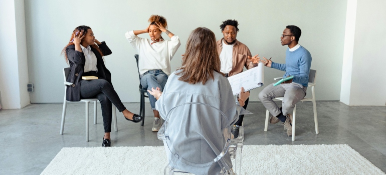 A therapist and four people in group therapy session