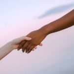 Two hands holding as a symbol of what to do when someone doesn't want help