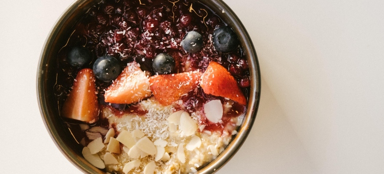 Bowl with healthy fruit on the white surface.