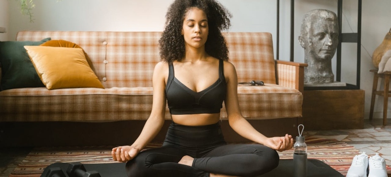 Woman meditating in order to avoid using antipsychotics and alcohol.