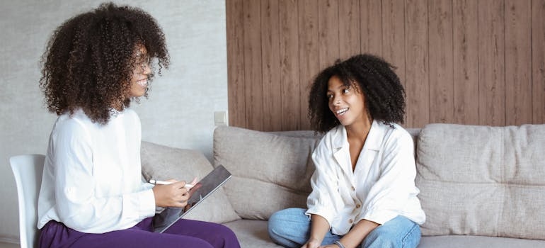 Woman sitting on a couch and talking to her therapist.