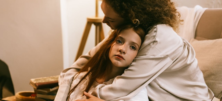 a mother hugging her daughter 