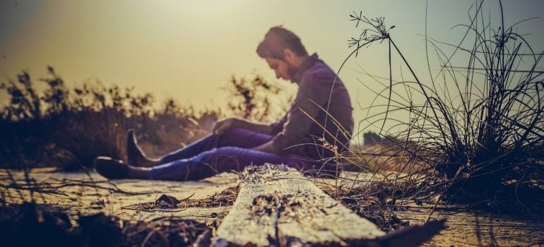 a man sitting on the ground and thinking about Introverts and Drug Use