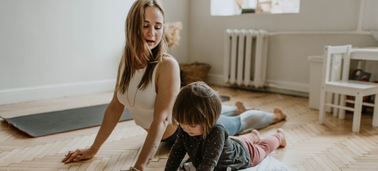 Woman doing yoga with her young child.