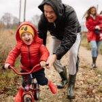 Father teaching his son to ride a bike.