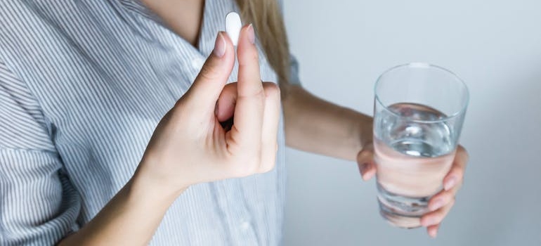 Woman taking a pill to help with OCD and addiction treatment.