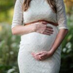 Pregnant woman holding her stomach.