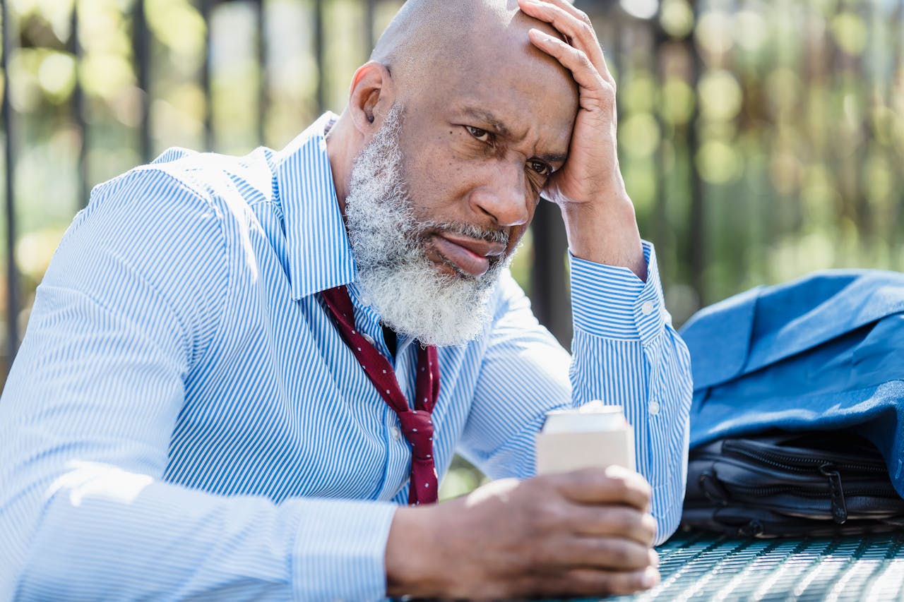 Older man holding a beer can and dealing with binge drinking and depression.