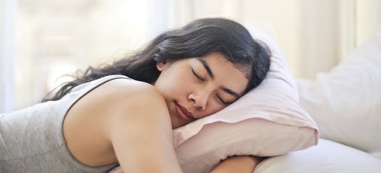 Woman hugging a pillow while sleeping.