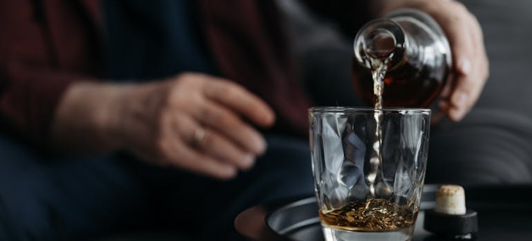 Man pouring whiskey into a glass.