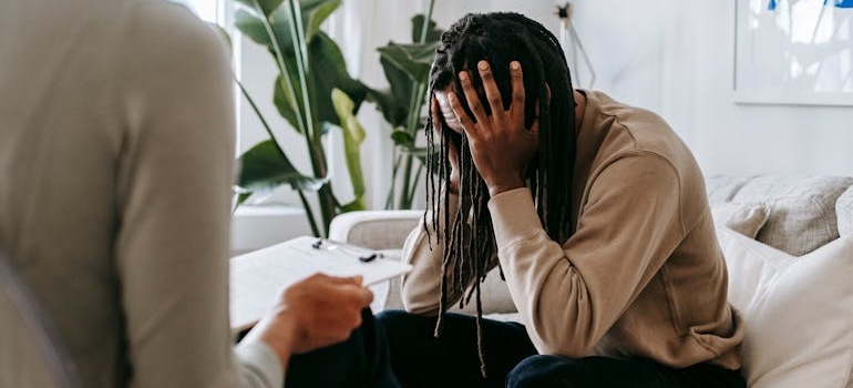 Man holding his head and talking to his therapist.