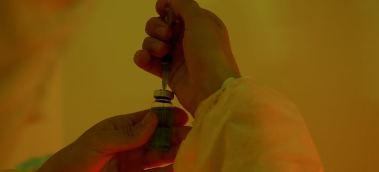 Man holding a syringe and a vial.