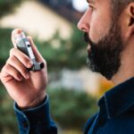 Man using an inhaler.