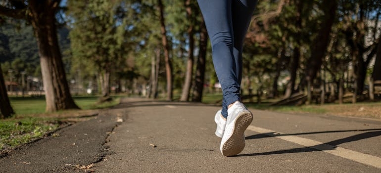 Person wearing blue jeans and walking on the street.