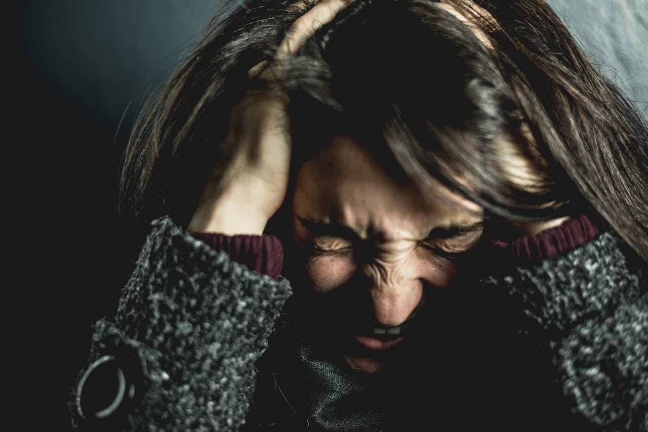 Woman holding her head in pain.