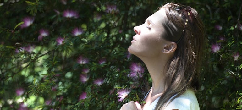 Woman with closed eyes looking up at the sun.