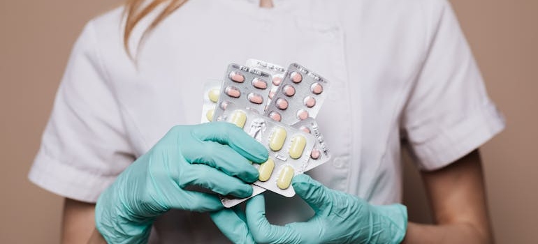 Female doctor holding blisters of pills.