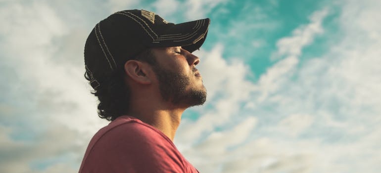 Man looking up at the sky and breathing.