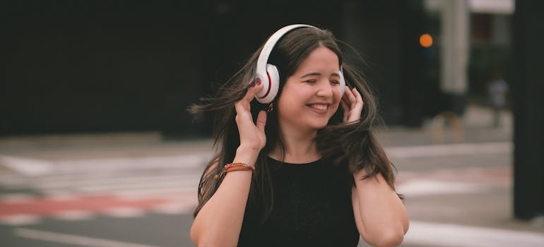 Woman laughing and listening to music with headphones.