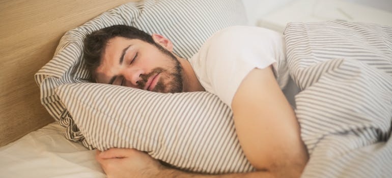 Man hugging his blanket and sleeping.