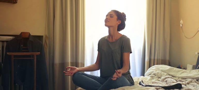 Woman sitting on the bed and meditating.