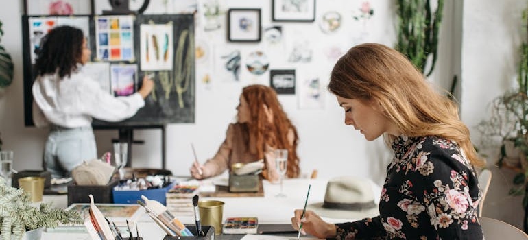 Three women sitting in a room and doing art therapy to help with addiction.