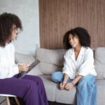 Woman sitting on a couch and talking to a therapist.