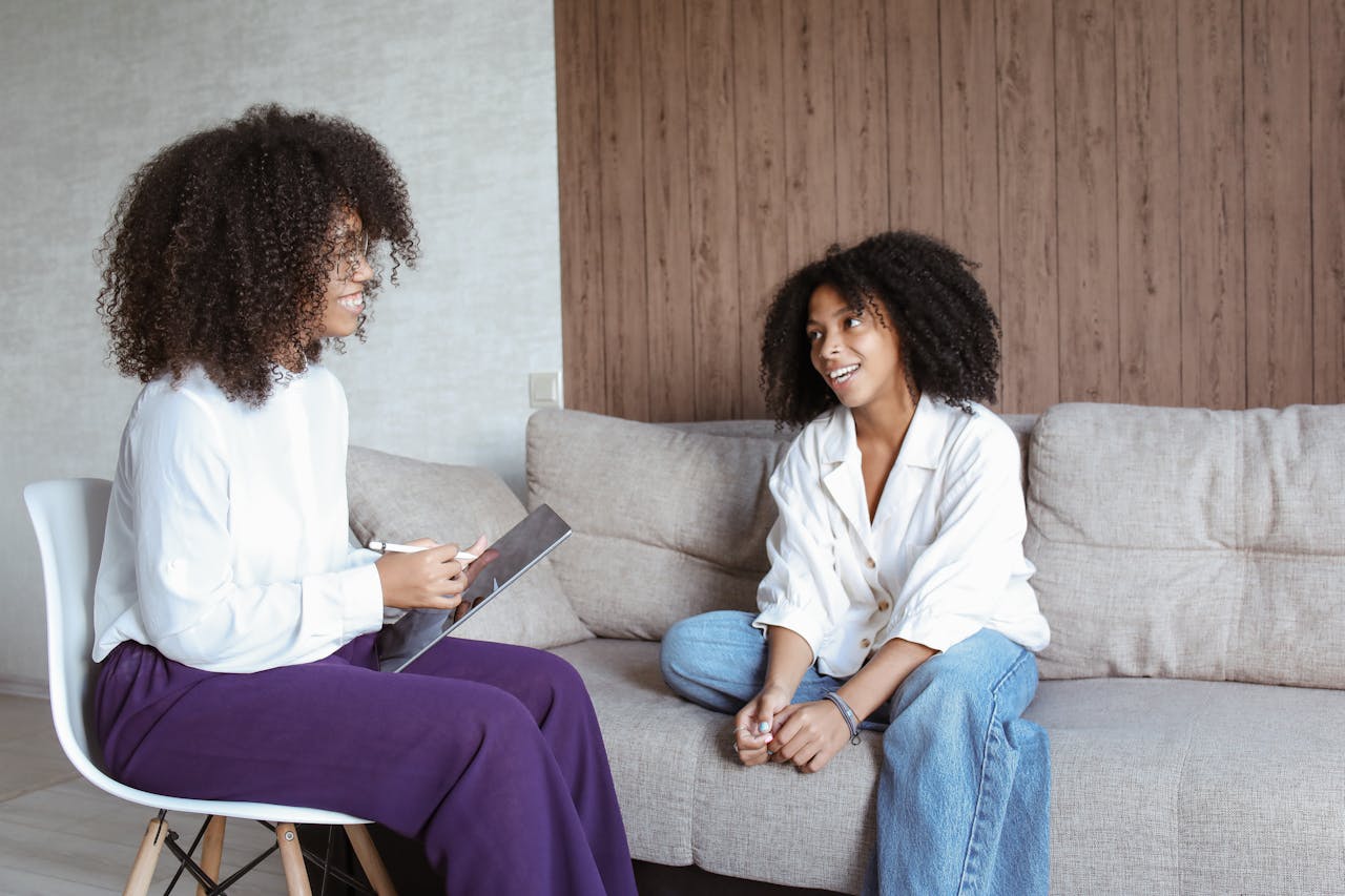 Woman sitting on a couch and talking to a therapist.